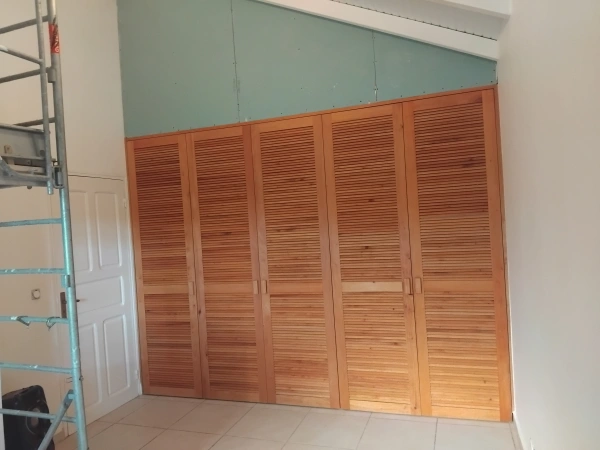 Dressing avec portes à persiennes de 2m40, (le chantier comporte 4 dressing, une commode, une porte intérieure) En mahogani local, sur mesure, fabrication artisanale.